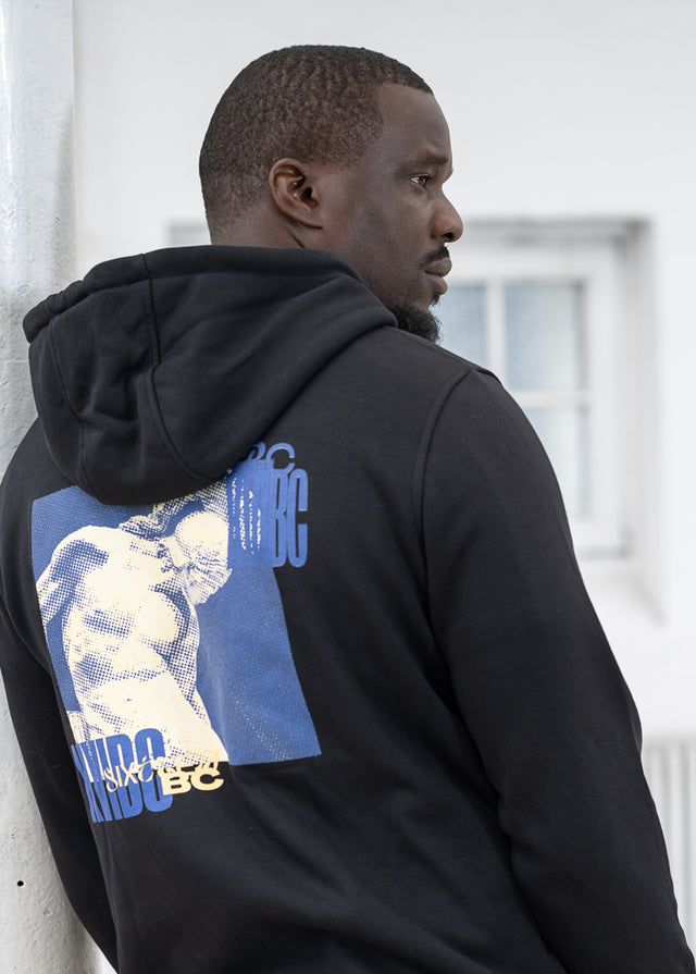 Rapper Mortel aus Trier trägt einen schwarzen 16BC Hoodie mit Gladiator-Backprint